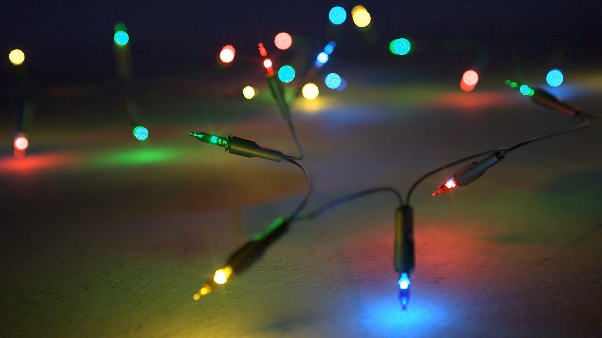 Realistic Christmas lights 3D model with glowing multicolor bulbs, festive decorative string lights on dark background.